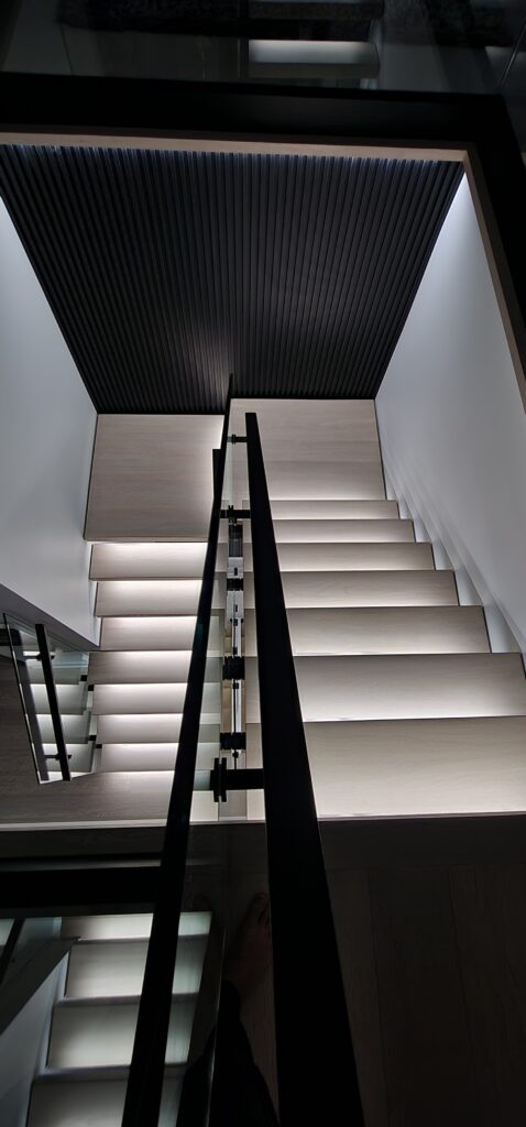 Modern staircase with LED strip lights installed under steps for enhanced visibility and design